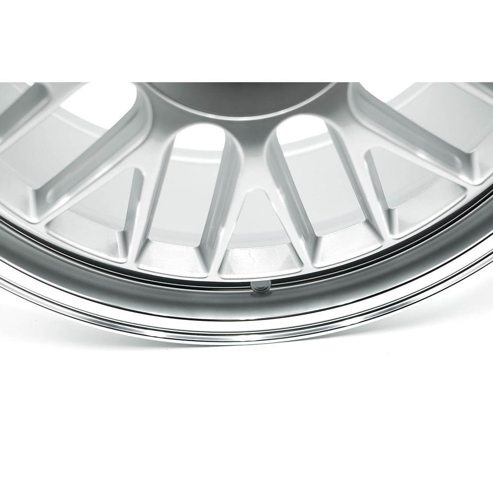 Close-up of a silver alloy wheel rim on a white background