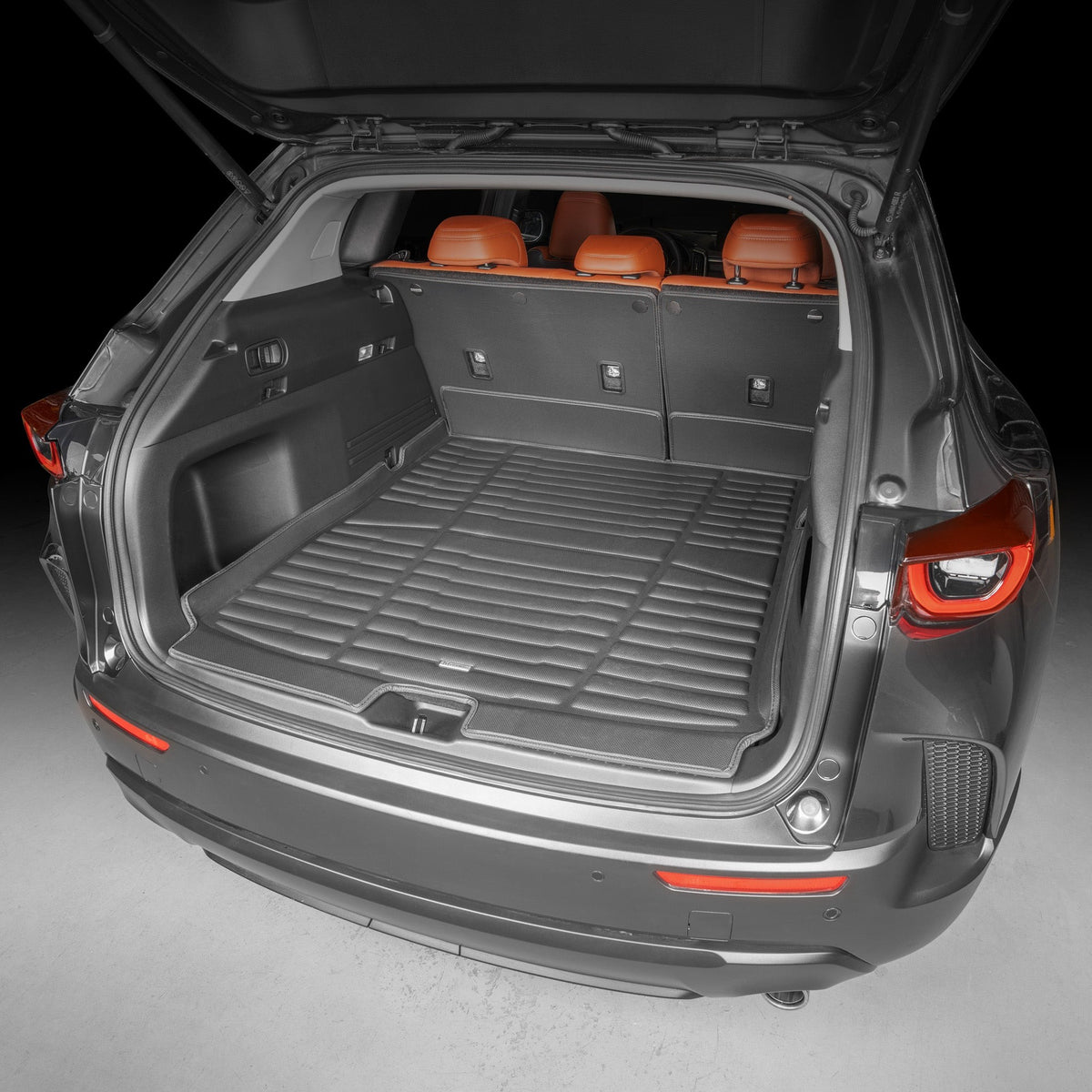 Open car trunk with a cargo mat on a gray background
