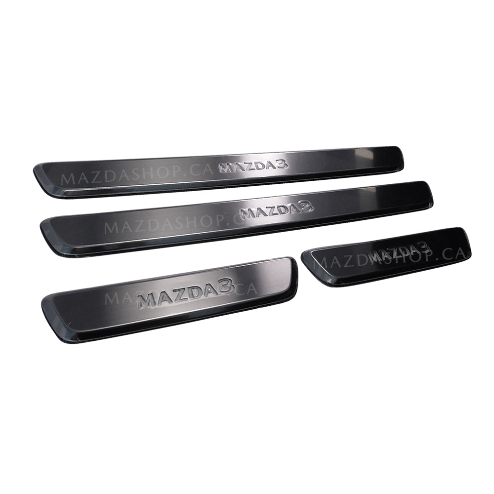 Four metallic door sill plates with 'MAZDA' branding on a white background