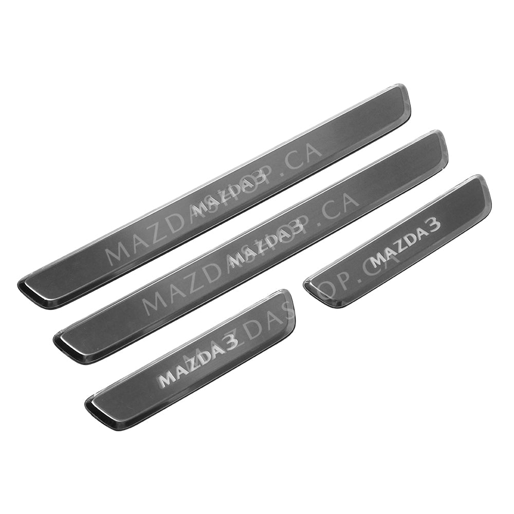 Set of five metallic Mazda door sill plates on a white background