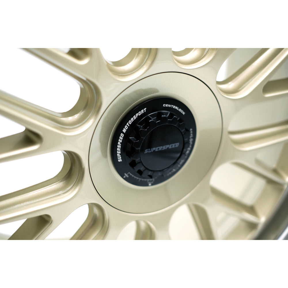 Close-up of a gold car wheel rim with 'Superspeed' branding on a white background