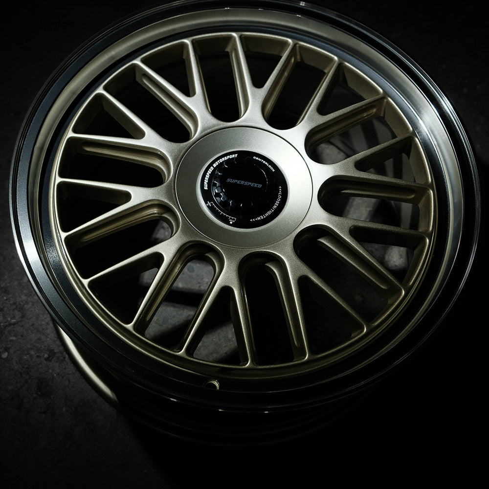 Close-up of a metallic alloy wheel with a dark background