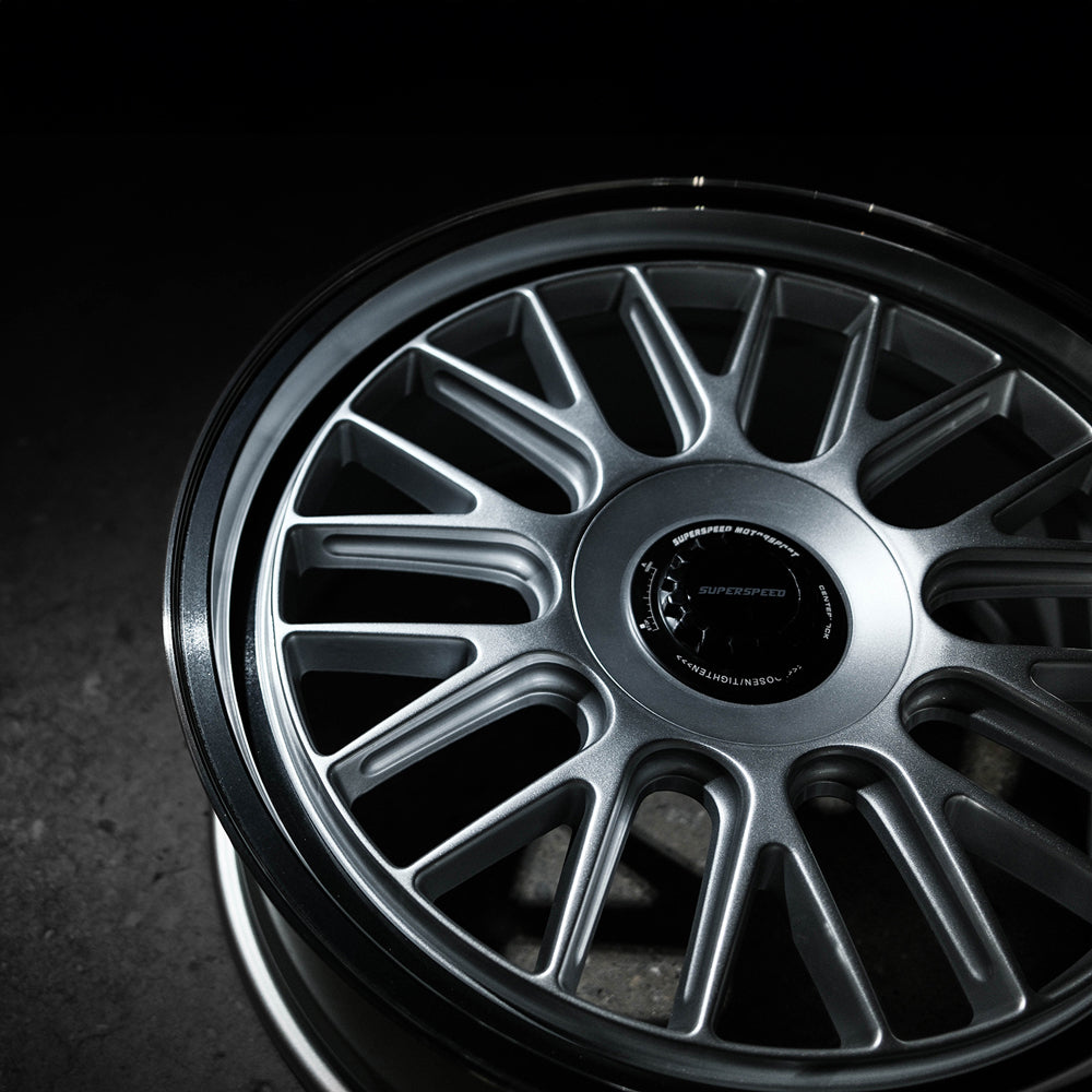 Close-up of a silver alloy wheel on a dark background