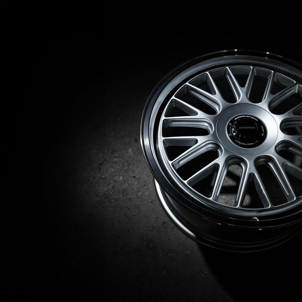 Close-up of a black alloy wheel on a dark background
